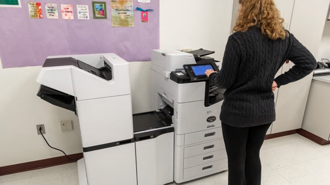 A woman using a business inkjet printer
